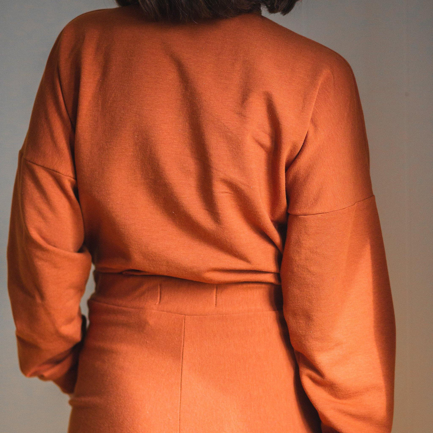 The back of a comfortable orange fleece turtle neck. Chic loungewear