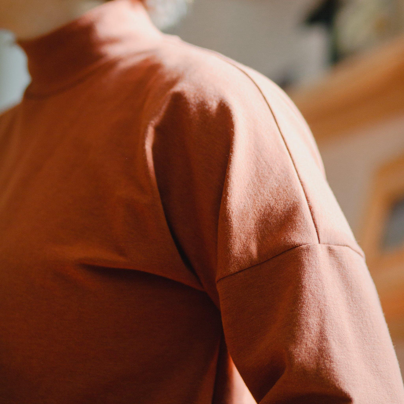 Close up of a comfortable fleece turtle neck. Quality loungewear orange.